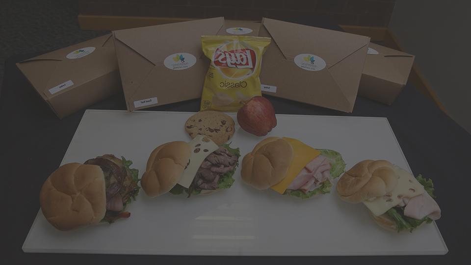 Plate of food with a sandwich, chips and cookie